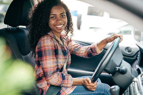 African-American teen holding the car steering wheel